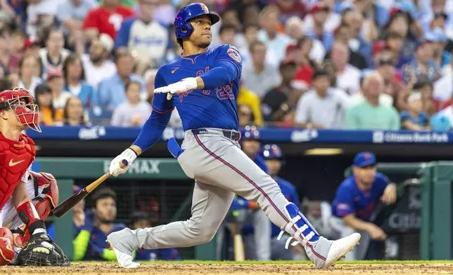 New York Mets' Juan Soto follows through on a solo home run in the third inning of a baseball game against the Philadelphia Phillies, Saturday, June 21, 2025, in Philadelphia. (AP Photo/Laurence Kesterson)