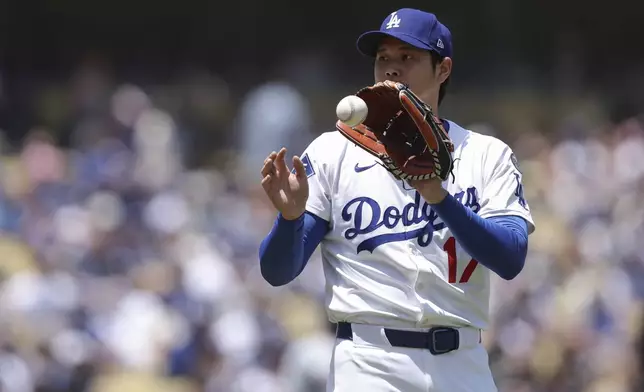 Los Angeles Dodgers starting pitcher Shohei Ohtani catches the ball during the first inning of a baseball game against the Washington Nationals in Los Angeles, Sunday, June 22, 2025. (AP Photo/Jessie Alcheh)