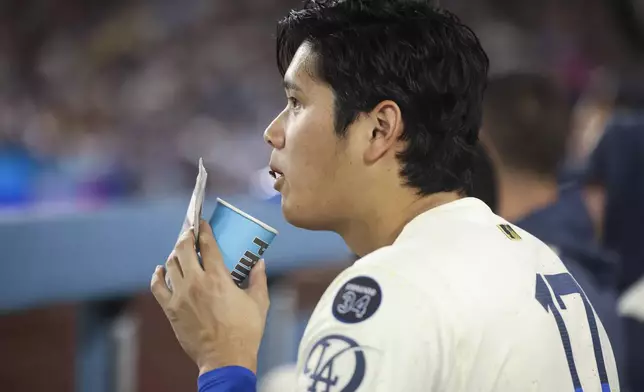 Los Angeles Dodgers designated hitter Shohei Ohtani eats sunflower seeds during the sixth inning of a baseball game against the Washington Nationals in Los Angeles, Saturday, June 21, 2025. (AP Photo/Jessie Alcheh)