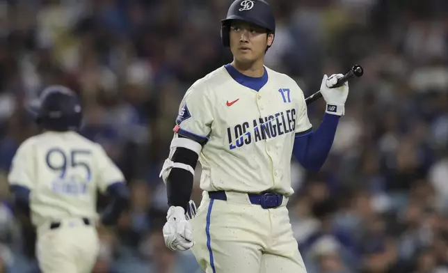 Los Angeles Dodgers designated hitter Shohei Ohtani looks on while walking to the dugout after striking out during the fifth inning of a baseball game against the Washington Nationals in Los Angeles, Saturday, June 21, 2025. (AP Photo/Jessie Alcheh)