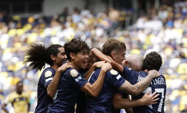 Auckland City's Christian Gray, second right, celebrates after scoring his side's opening goal with teammates during the Club World Cup Group C soccer match between Auckland City and Boca Juniors in Nashville, Tenn., Tuesday, June 24, 2025. (AP Photo/Johnnie Izquierdo)
