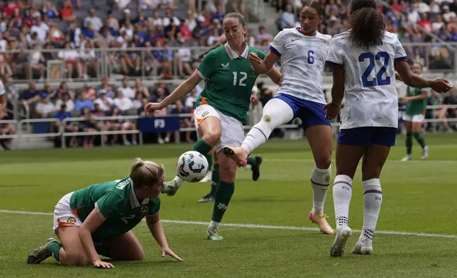 United States forward Lynn Biyendolo (6) kicks the ball past Ireland defenders Jessie Stapleton (2) and Anna Patten (12) as United States forward Yazmeen Ryan (22) moves in during the first half of an international friendly women's soccer match in Cincinnati, Sunday, June 29, 2025. (AP Photo/Carolyn Kaster)