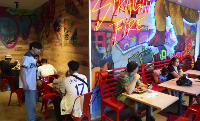 Customers eat inside Dave's Hot Chicken restaurant in the Little Tokyo district of Los Angeles Monday, June 2, 2025. (AP Photo/Damian Dovarganes)
