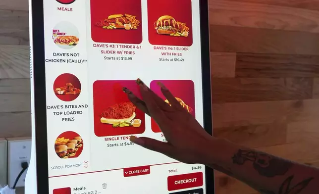 A customer uses a touch screen to order inside Dave's Hot Chicken restaurant in the Little Tokyo district of Los Angeles Monday, June 2, 2025. (AP Photo/Damian Dovarganes)