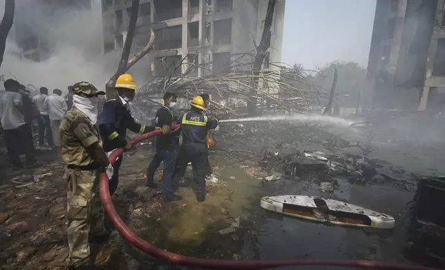 Firefighters work at the site of an airplane that crashed in India's northwestern city of Ahmedabad in Gujarat state, Thursday, June 12, 2025. (AP Photo/Ajit Solanki)