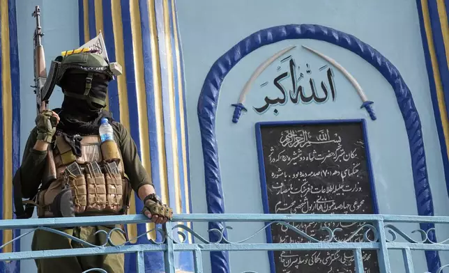 A Taliban fighter stands guard next to the Shah-Do Shamshira Mosque while people attend the Eid al-Adha prayer in Kabul, Afghanistan, Saturday, June 7, 2025. (AP Photo/Ebrahim Noroozi)