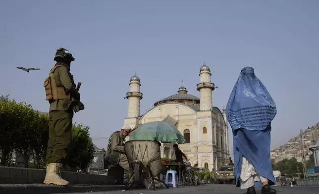 A Taliban fighter stands guard near the Shah-Do Shamshira Mosque as people attend the Eid al-Adha prayer in Kabul, Afghanistan, Saturday, June 7, 2025. (AP Photo/Ebrahim Noroozi)
