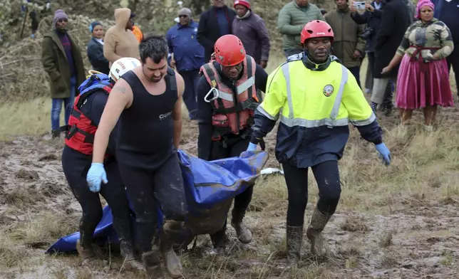 Rescue workers transport a person in a body bag during a rescue operation after floods swept through the area, in Mthatha, South Africa, Wednesday, June 11, 2025. (AP Photo/Hoseya Jubase)