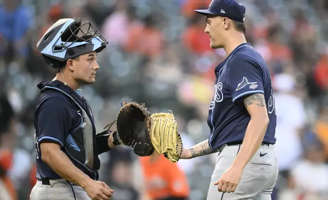 Tampa Bay Rays relief pitcher Joe Rock, right, and catcher Matt Thaiss, left, celebrate after a baseball game against the Baltimore Orioles, Saturday, June 28, 2025, in Baltimore. (AP Photo/Nick Wass)