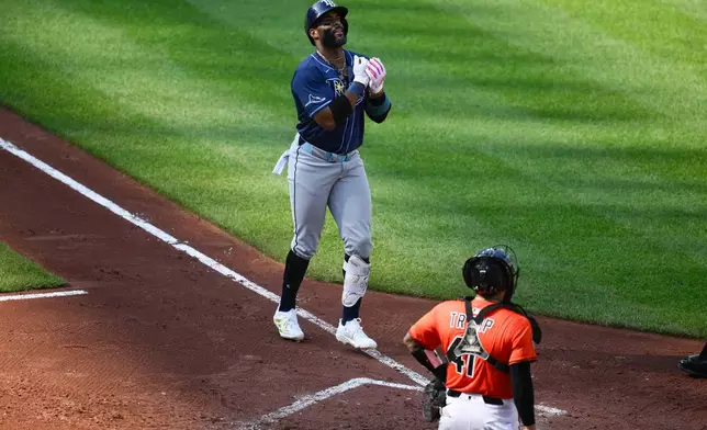 Tampa Bay Rays' Yandy Diaz, left, celebrates his three-run home run during the fourth inning of a baseball game as Baltimore Orioles catcher Chadwick Tromp looks on at right, Saturday, June 28, 2025, in Baltimore. (AP Photo/Nick Wass)