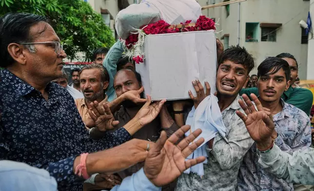 Brother, second right, family members and relatives carry coffin of Akash Patni, victim of the Air India plane crash, grieve during his funeral procession in Ahmedabad, India, Tuesday, June 17, 2025. (AP Photo/Ajit Solanki)