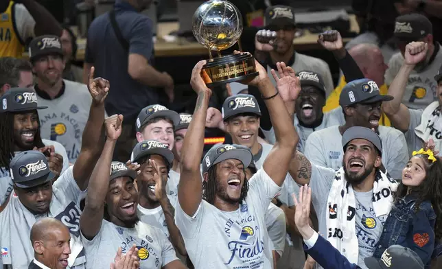 Indiana Pacers center Myles Turner holds the trophy as players celebrate after winning Game 6 of the Eastern Conference finals of the NBA basketball playoffs against the New York Knicks in Indianapolis, Saturday, May 31, 2025. (AP Photo/AJ Mast)