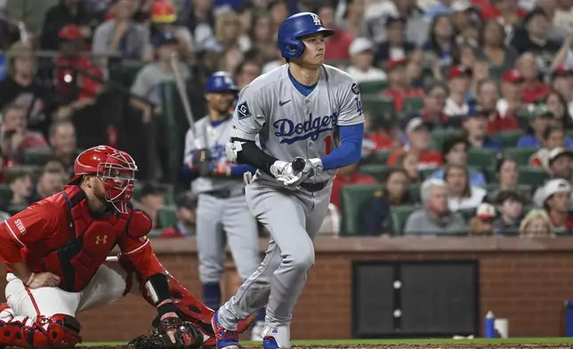 Los Angeles Dodgers' Shohei Ohtani, right, watches his single next to St. Louis Cardinals catcher Pedro Pages, left, in the third inning of a baseball game, Friday, June 6, 2025, in St. Louis. (AP Photo/Joe Puetz)