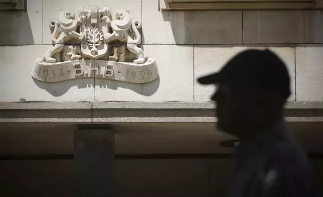 A man passes by a Bulgarian National Bank logo in Sofia, Bulgaria, Monday, June 2, 2025. (AP Photo Valentina Petrova)