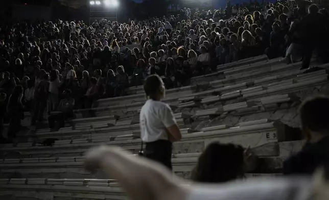 Ushers help spectators taking their seats at the Odeon of Herodes Atticus ahead of Giacomo Puccini's "Turandot" dress rehearsal during the 70th Athens Epidaurus Festival in Athens, Greece, Friday, May 30, 2025. (AP Photo/Thanassis Stavrakis)