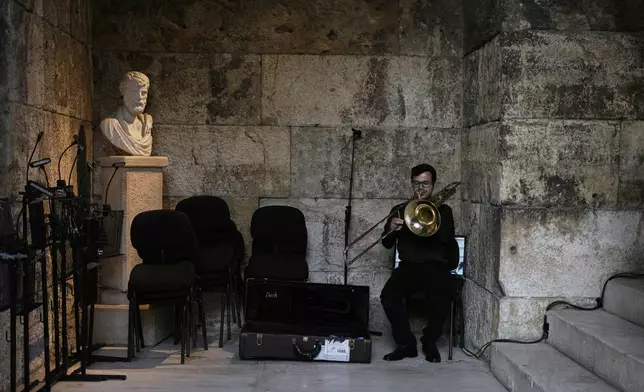 Greek National Opera musician Neoklis Aravantinos plays his bass trombone ahead of Giacomo Puccini's "Turandot" premiere during the 70th Athens Epidaurus Festival at the Odeon of Herodes Atticus in Athens, Greece, Sunday, June 1, 2025. (AP Photo/Thanassis Stavrakis)