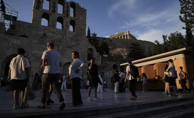Spectators wait to enter the Odeon of Herodes Atticus for Giacomo Puccini's "Turandot" premiere by the Greek National Opera during the 70th Athens Epidaurus Festival in Athens, Greece, Sunday, June 1, 2025. (AP Photo/Thanassis Stavrakis)