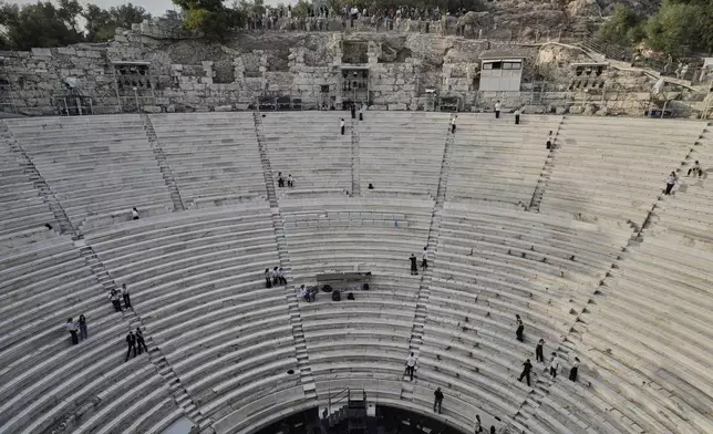 Tourists watch the ushers as they prepare the Odeon of Herodes Atticus ahead of the dress rehearsal of Giacomo Puccini's "Turandot" by the Greek National Opera during the 70th Athens Epidaurus Festival in Athens, Greece, Friday, May 30, 2025. (AP Photo/Thanassis Stavrakis)