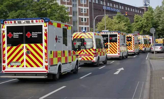 Ambulances drive to the Eduardus Hospital in Cologne-Deutz to evacuate the hospital before specialists defuse three unexploded U.S. bombs from World War II that were unearthed earlier this week in Cologne, Wednesday, June 4, 2025. (Henning Kaiser/dpa via AP)
