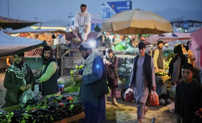 People shop in a market a day before the Eid al-Adha, or "Feast of the Sacrifice", in Kabul, Afghanistan, Friday, June 6, 2025. (AP Photo/Ebrahim Noroozi)