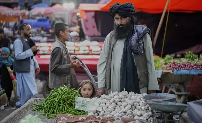 People shop in a market a day before the Eid al-Adha, or "Feast of the Sacrifice", in Kabul, Afghanistan, Friday, June 6, 2025. (AP Photo/Ebrahim Noroozi)