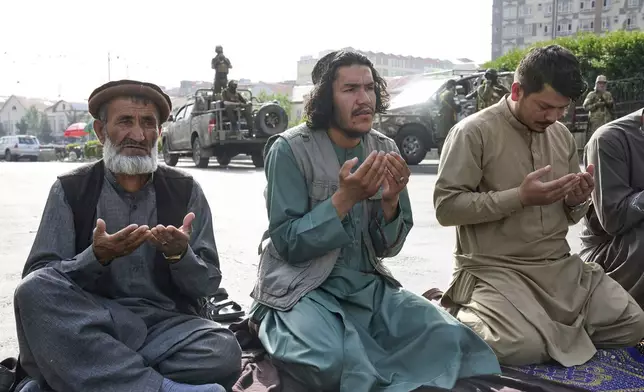 Afghan Muslims perform Eid al-Adha. or "Feast of the Sacrifice" prayer while Taliban fighters stand guard outside the Shah-Do Shamshira Mosque in Kabul, Afghanistan, Saturday, June 7, 2025. (AP Photo/Ebrahim Noroozi)