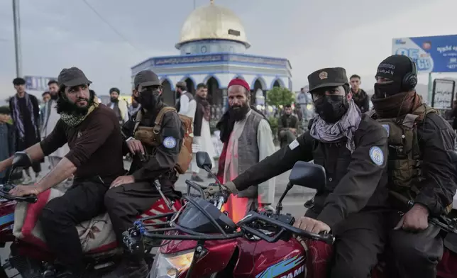 Taliban fighters stand guard next to a market ahead of Eid al-Adha, or "Feast of the Sacrifice", in Kabul, Afghanistan, Thursday, June 5, 2025. (AP Photo/Ebrahim Noroozi)