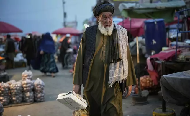 An Afghan man shops in a market a day before the Eid al-Adha, or "Feast of the Sacrifice", in Kabul, Afghanistan, Friday, June 6, 2025. (AP Photo/Ebrahim Noroozi)