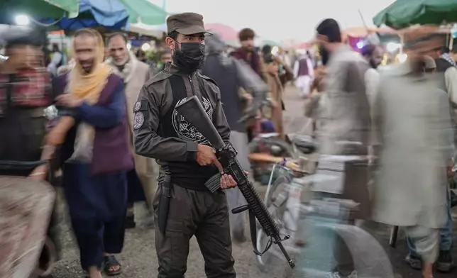 A Taliban fighter stands guard in a market ahead of Eid al-Adha, or "Feast of the Sacrifice", in Kabul, Afghanistan, Thursday, June 5, 2025. (AP Photo/Ebrahim Noroozi)