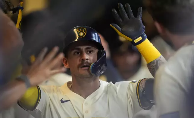 Milwaukee Brewers' Joey Ortiz is congratulated in the dugout after hitting a two-run home run during the third inning of a baseball game against the Pittsburgh Pirates, Tuesday, June 24, 2025, in Milwaukee. (AP Photo/Aaron Gash)