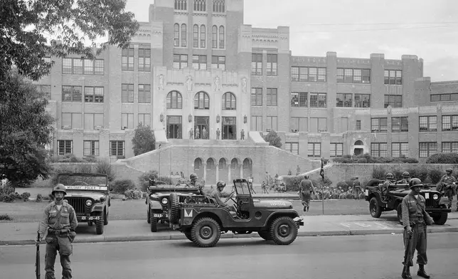 FILE - In this Sept. 26, 1957, file photo, members of the 101st Airborne Division take up positions outside Central High School in Little Rock, Ark. The troops were on duty to enforce integration at the school. (AP Photo/File)