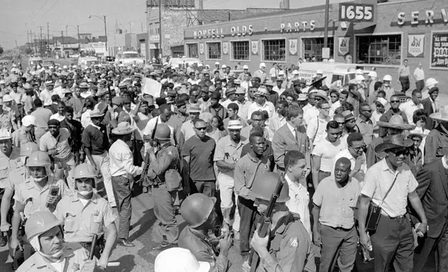 FILE - A civil rights march is conducted on Sept. 4, 1966 in close quarters on Cicero Ave., a main street of this suburb of Chicago. At left, the police; then National Guardsmen with bayonets on rifles, then marchers, then crowd. (AP Photo, file)