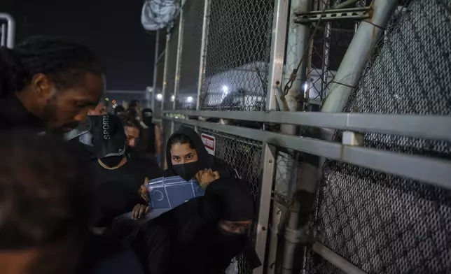 A Protester shouts at an Immigration and Customs Enforcement (ICE) officer through the gate of the Delaney Hall Immigration Facility during a protest over federal immigration enforcement raids on Thursday, June 12, 2025, in Newark, N.J. (AP Photo/Olga Fedorova)