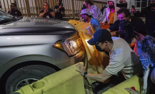 Protesters attempt to block a vehicle from leaving the Delaney Hall Detention Facility during protests over federal immigration enforcement raids on Thursday, June 12, 2025, in Newark, N.J. (AP Photo/Olga Fedorova)