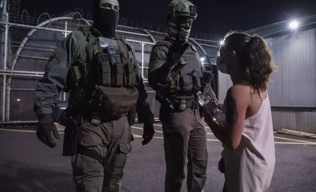 A protester confronts immigration enforcement agents outside the Delaney Hall Detention Facility during a protest over federal immigration enforcement raids on Thursday, June 12, 2025, in Newark, N.J. (AP Photo/Olga Fedorova)