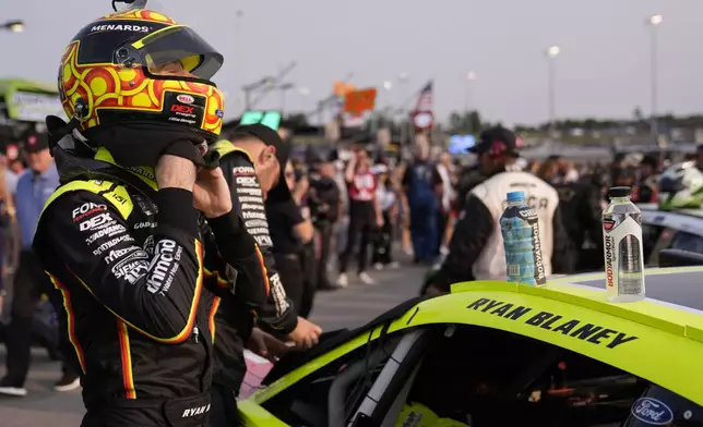 Ryan Blaney straps on his helmet before a NASCAR Cup Series auto race Sunday, June 1, 2025, in Lebanon, Tenn. (AP Photo/George Walker IV)