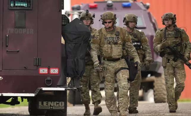 Members of law enforcement agencies search for shooting suspect, Vance Boelter, at a house Sunday, June 15, 2025, in Belle Plaine, Minn. (AP Photo/George Walker IV)