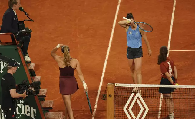 France's Lois Boisson, centre right, and Russia's Mirra Andreeva attend a break during their quarterfinal match of the French Tennis Open at the Roland-Garros stadium in Paris, Wednesday, June 4, 2025. (AP Photo/Aurelien Morissard)