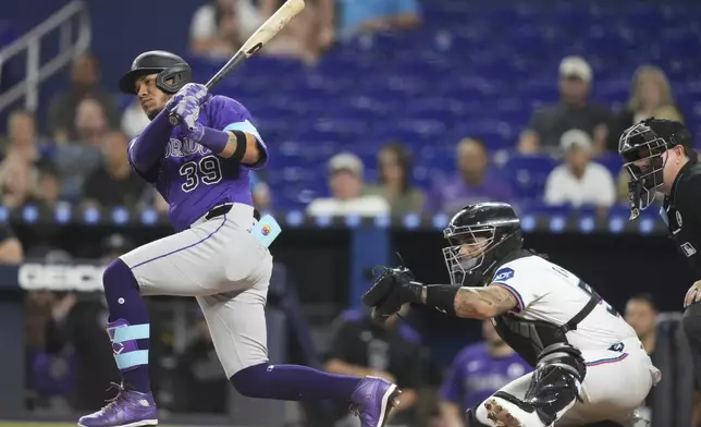 Colorado Rockies' Thairo Estrada (39) follows through on a RBI-double to score Hunter Goodman during the first inning of a baseball game against the Miami Marlins, Monday, June 2, 2025, in Miami. (AP Photo/Lynne Sladky)