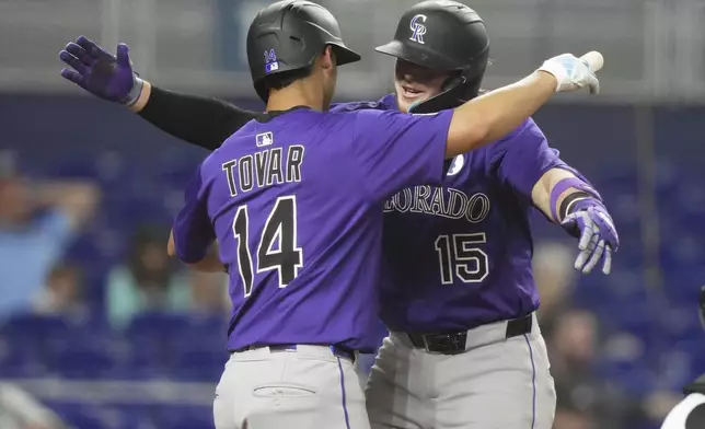 Colorado Rockies' Hunter Goodman (15) is met at the plate by Ezequiel Tovar (14) after hitting a solo home run during the fifth inning of a baseball game against the Miami Marlins, Monday, June 2, 2025, in Miami. (AP Photo/Lynne Sladky)