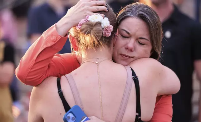 U.S. Rep. Angie Craig, D-Minn., embraces a woman while attending a candlelight vigil for Minnesota state Rep. Melissa Hortman and her husband Mark at the State Capitol, Wednesday, June 18, 2025, in St. Paul, Minn. (AP Photo/Nikolas Liepins)