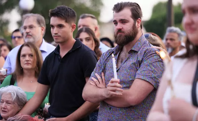 Colin Hortman, right, attends a candlelight vigil for his parents, former House Speaker Melissa Hortman and her husband Mark, who were fatally shot, at the state Capitol, Wednesday, June 18, 2025, in St. Paul, Minn. (AP Photo/Nikolas Liepins)