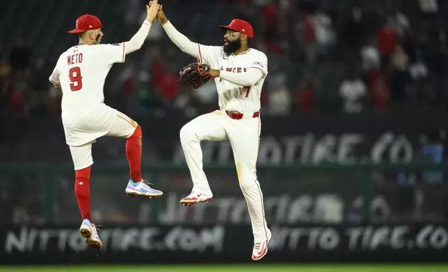 Los Angeles Angels' Jo Adell, right, celebrates with Zach Neto after winning a baseball game against the Athletics, Monday, June 9, 2025, in Anaheim, Calif. (AP Photo/William Liang)