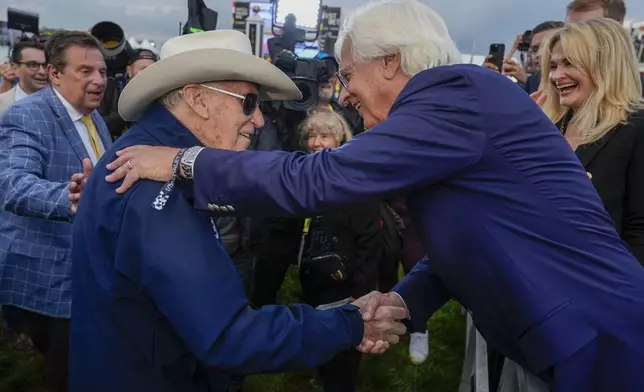 FILE - Seize The Grey's trainer D. Wayne Lukas, left, shakes hands with with Bob Baffert, Imagination's trainer, after Lukas' horse won the Preakness Stakes horse race at Pimlico Race Course, May 18, 2024, in Baltimore. (AP Photo/Julia Nikhinson, file)