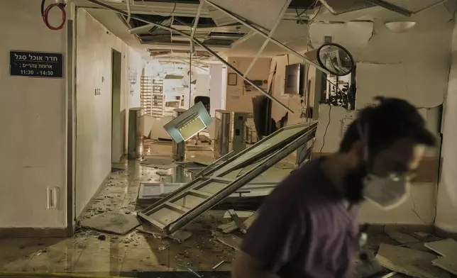 A medical staffer walks in a damaged area of the Soroka hospital complex in Beersheba, Israel, after it was hit by a missile fired from Iran, Thursday, June 19, 2025. (AP Photo/Leo Correa)