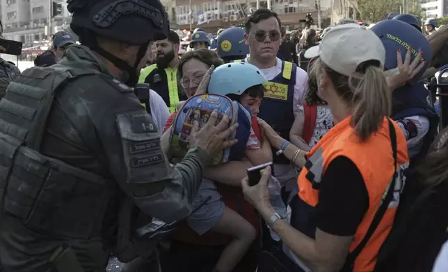 A child is evacuated from the site of a direct hit from an Iranian missile strike in Ramat Gan, Israel, Thursday, June 19, 2025. (AP Photo/Oded Balilty)