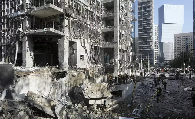 Rescue workers and military personnel inspect the site of a direct hit from an Iranian missile strike in Ramat Gan, Israel, Thursday, June 19, 2025. (AP Photo/Oded Balilty)