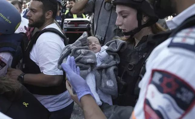 A baby is evacuated from the site of a direct hit from an Iranian missile strike in Ramat Gan, Israel, Thursday, June 19, 2025. (AP Photo/Oded Balilty)