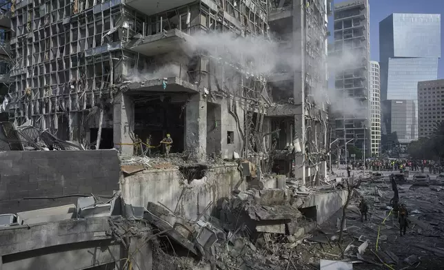 Rescue workers and military personnel inspect the site of a direct hit from an Iranian missile strike in Ramat Gan, Israel, Thursday, June 19, 2025. (AP Photo/Oded Balilty)