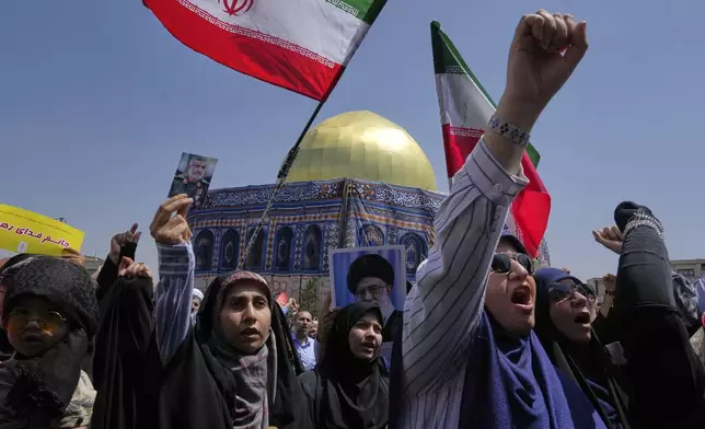 Iranian protesters chant slogans as one of them holds up a portrait of Iran's Revolutionary Guard aerospace division commander, Gen. Amir Ali Hajizadeh, who was killed in an Israeli strike on Iran, in front of a model of Jerusalem's Dome of the Rock mosque, during a protest to condemn Israeli attacks on multiple cities across Iran, after Friday prayers ceremony in Tehran, Iran, Friday, June 20, 2025. (AP Photo/Vahid Salemi)